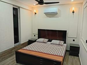 a bed in a room with a ceiling fan at Alfazal apartment in Lahore
