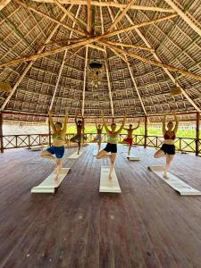 a group of women doing a yoga pose in a gym at Nilio Explorer & Lodge in Mfumbwi