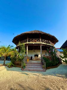 a building with a straw roof on the beach at Nilio Explorer & Lodge in Mfumbwi