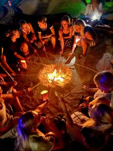 a group of people sitting around a fire at Nilio Explorer & Lodge in Mfumbwi +29 photos