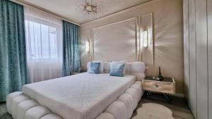 a bedroom with a large white bed with blue pillows at Louise Luxury - free parking in Nyíregyháza