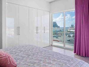 a bedroom with white cabinets and a large window at Milateo Suite in Oranjestad +9 photos
