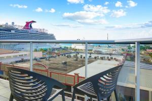a balcony with chairs and a cruise ship at Milateo Suite in Oranjestad
