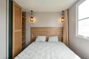 a bedroom with a bed with two pillows and a window at Camping Papillon Bouillon - Vakantiehuis Premium Rustige Locatie in Bouillon