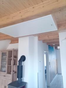 a room with a wooden ceiling and a stove at Fewo Zur Windmühle in Pegau +8 photos