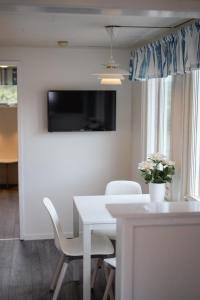 a white dining room with a white table and chairs at GrebbestadFjorden stugor in Grebbestad