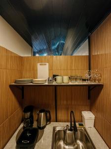a kitchen with a sink and a shelf with plates and glasses at Espaços Cardoso, HORIZONTE- amplitude e respiro in Igrejinha +24 photos
