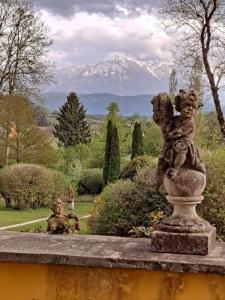 a statue of two cherubs on a wall in a garden at Ferienwohnung Ottmanach Josefhof in Pischeldorf