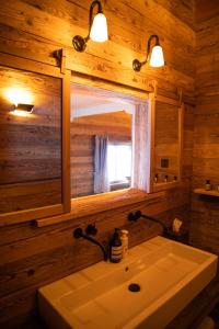 a bathroom with a sink and a mirror at Berghuus Radons in Savognin