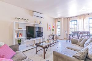 a living room with a couch and a tv at Palma Divine Condo-2BR-2BTH-Pool in Noord