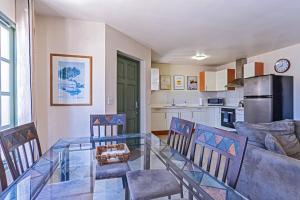 a dining room and kitchen with a glass table at Palma Divine Condo-2BR-2BTH-Pool in Noord