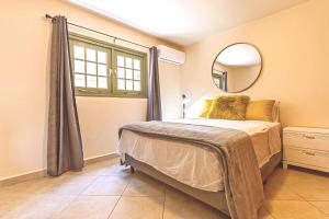 a bedroom with a bed with a mirror and a window at Palma Divine Condo-2BR-2BTH-Pool in Noord +10 photos