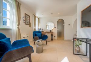 a living room with blue chairs and a desk at Santa Boka Small Luxury Hotels of the World in Perast