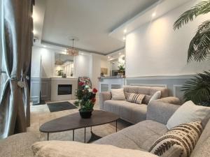 a living room with two couches and a table at CITY PARC HOTEL - Proche Paris Nord & CDG Aéroport - Parc des Expositions in Aulnay-sous-Bois