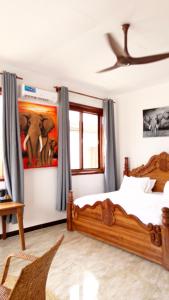 a bedroom with two beds and a painting on the wall at Jamaica House in Nungwi