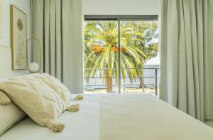 a bedroom with a bed with a view of a palm tree at Palmas de la Laguna by Posada Suiza in San Miguel del Monte +36 photos