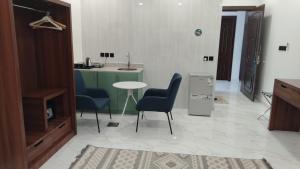 a kitchen with two chairs and a table and a sink at ﻣﺆﺳﺴﺔ ﺷﻘﻖ ﺍﻟﻘﺎﺭﺍﺕ ﺍﻟﺴﺒﻊ ﺍﻟﻤﺨﺪﻭﻣﺔ in Al Nairyah