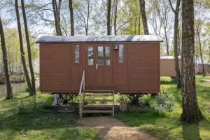 a wooden cabin in the middle of the woods at Camping Papillon Kinrooi - Pipowagen 2p in Kinrooi +8 photos