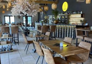 a restaurant with tables and chairs and a bar at Camping Papillon Kinrooi - Pipowagen 2p in Kinrooi