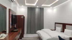 a bedroom with a bed and a desk and a television at ﻣﺆﺳﺴﺔ ﺷﻘﻖ ﺍﻟﻘﺎﺭﺍﺕ ﺍﻟﺴﺒﻊ ﺍﻟﻤﺨﺪﻭﻣﺔ in Al Nairyah