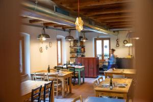 a restaurant with wooden tables and chairs and a woman at Limarò B&B in Sarche di Calavino