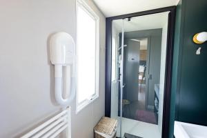 a bathroom with a mirror next to a window at Camping Papillon Kinrooi - Vakantiehuis Familie 6P in Kinrooi