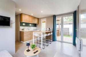 a kitchen and living room with a counter and a table at Camping Papillon Kinrooi - Vakantiehuis Familie 6P in Kinrooi