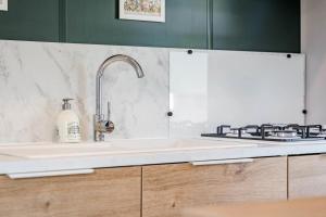 a kitchen with a sink and a stove at Camping Papillon Kinrooi - Vakantiehuis Familie 6P in Kinrooi