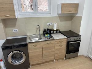 a small kitchen with a sink and a washing machine at Natalie's Lodge in Belgrade
