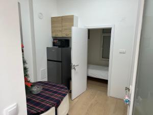 a small room with a refrigerator and a bedroom at Natalie's Lodge in Belgrade