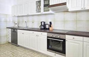 a kitchen with white cabinets and a stove top oven at Apartment Put Mocila Vi in Otok Mrduja