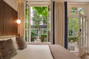a bedroom with a bed and a large window at Lord Byron in Paris