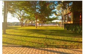a field of grass with trees and a building at The Ivy Hotel in Lusaka