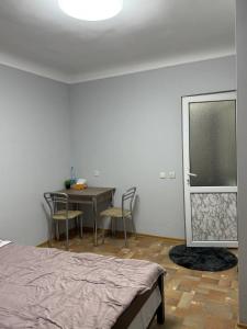 a bedroom with a bed and a table and chairs at Cozy Grey Studio in Chişinău +16 photos