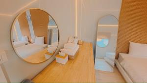 a bedroom with a mirror and a bed and a chair at Hotelru Koh Larn-โฮเต็ลรุ เกาะล้าน in Ko Lan