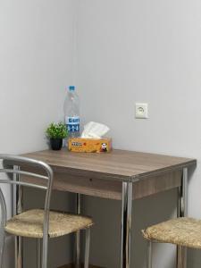 a table with a bottle of water and two chairs at Cozy Grey Studio in Chişinău