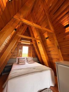 a bed in the attic of a wooden cabin at Vale dos Ventos - Chalés e Hospedagem in Jaboticatubas +35 photos