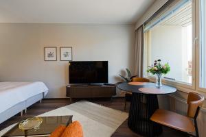 a room with a bed and a tv and a table at Studio Esterinkatu in Imatra