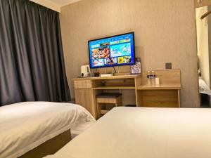 a hotel room with a bed and a flat screen tv at 木子酒店 in Nanjing