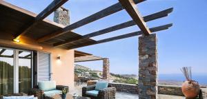 a patio with chairs and a view of the ocean at Cycladic Villa with sea view! in Ioulis