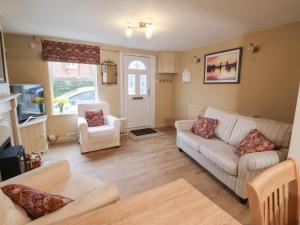a living room with a couch and two chairs at Lilly Cottage in Woodbridge