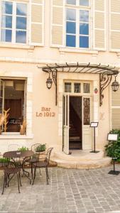 a building with a table and chairs in front of it at La P'tite Maison D'Auron in Bourges
