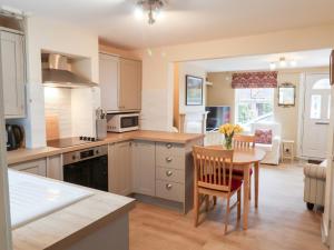 a kitchen with a table and a dining room at Lilly Cottage in Woodbridge
