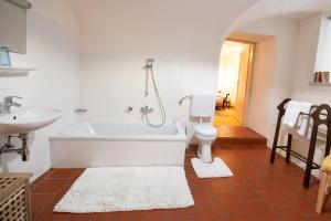 a bathroom with a tub and a toilet and a sink at Ferienwohnung Ottmanach Josefhof in Pischeldorf +23 photos
