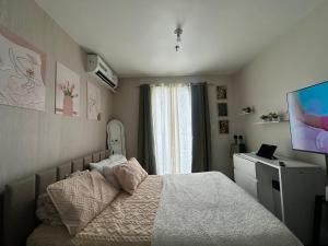a small bedroom with a bed and a television at Saekyung 301-1603 in Concepcion