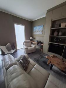 a living room with a couch and a tv at Huis aan Puyenbroeck in Wachtebeke
