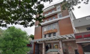 a building with a sign in front of it at Starlight Hotels Palm Tree Mylapore Ramakrishna Mutt Road chennai in Chennai