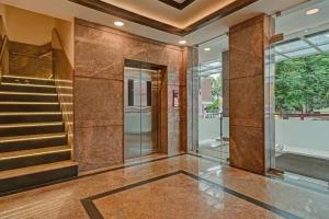 a lobby with a staircase in a building at Starlight Hotels Palm Tree Mylapore Ramakrishna Mutt Road chennai in Chennai