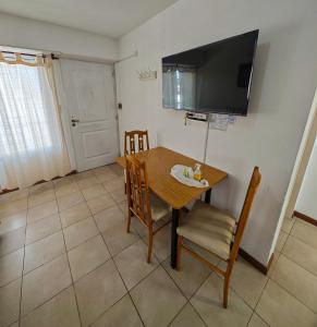 a dining room with a table and chairs and a television at Depto AC Olavarria in Olavarría