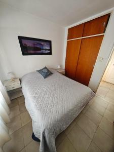 a bedroom with a bed and a tv on the wall at Depto AC Olavarria in Olavarría